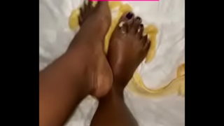 Pekné ebenové nohy sa hrajú s banánom